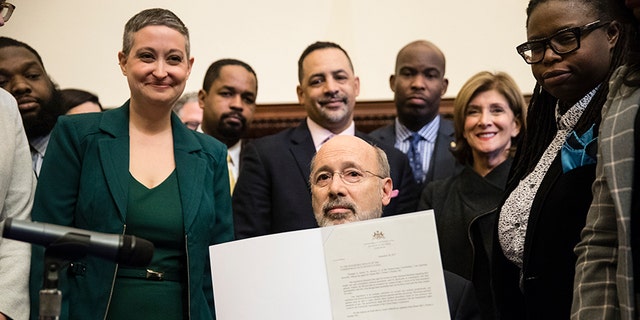 Pennsylvania Gov. Tom Wolf displays his signature after vetoing a bill passed by the Republican-controlled Legislature to limit abortions to the first 20 weeks of pregnancy at City Hall in Philadelphia, Monday, Dec. 18, 2017.