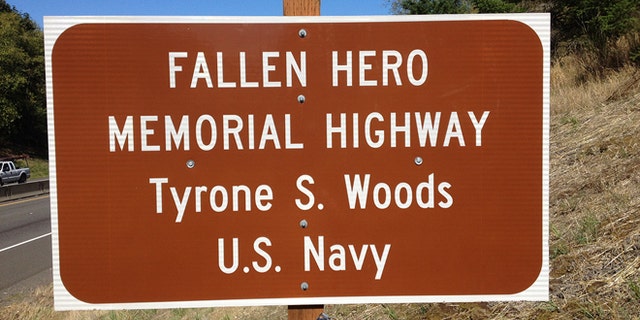 An Oregon sign reflects a stretch of highway dedicated in memory of Tyrone Woods, who was killed in the 2012 Benghazi attack.