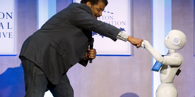 File photo: Astrophysicist Neil deGrasse Tyson interacts with Pepper, a social humanoid robot developed by Aldebaran for SoftBank, during the Clinton Global Initiative's annual meeting in New York, September 28, 2015. (REUTERS/Lucas Jackson)