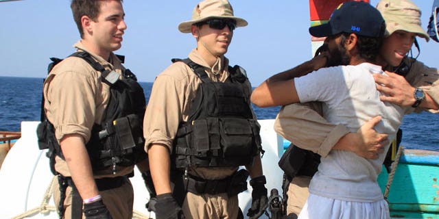 January 6, 2012: U.S. Navy sailors assigned to the guided-missile destroyer USS Kidd greet a crew member of the Iranian fishing vessel, the Al Molai Fin the Arabian Sea.