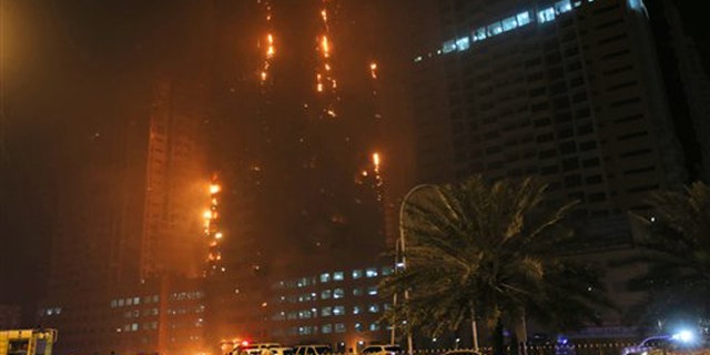 Fire and smoke billow from a high-rise building in Ajman, United Arab Emirates, early Tuesday, March 29, 2016. Police in the United Arab Emirates city of Ajman confirmed the fire erupted at the high-rise tower, the latest in a series of skyscraper blazes in the Gulf nation, but gave no details of casualties. (AP Photo/Kamran Jebreili)