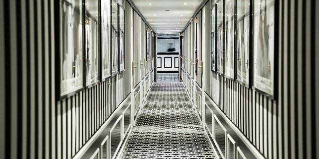 Chic black-and-white wallpaper lines a hallway on one of the "millennial" cruise ships.