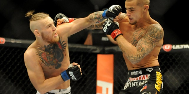 Sep 27, 2014; Las Vegas, NV, USA; Conor McGregor (blue gloves) fights Dustin Poirier (red gloves) during a featherweight fight during UFC 178 at MGM Grand Garden Arena. Mandatory Credit: Stephen R. Sylvanie-USA TODAY Sports
BEST QUALITY AVAILABLE - RTR47ZES