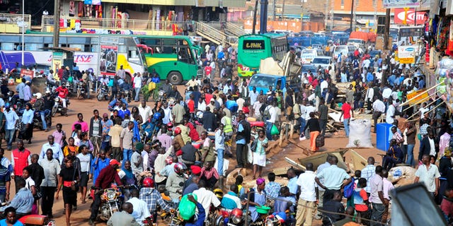 In this Saturday Oct. 1, 2011 photo, people gather at a bus terminal in Kampala, Uganda.