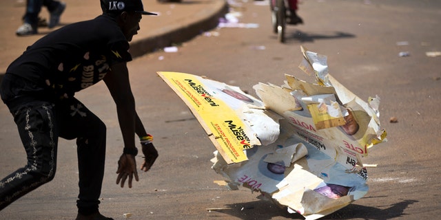 Feb. 18, 2016: An angry voter smashes a campaign placard of long-time President Yoweri Museveni, outside a polling station where voting material for the presidential election never arrived, at a polling station in Ggaba, on the outskirts of Kampala, in Uganda.