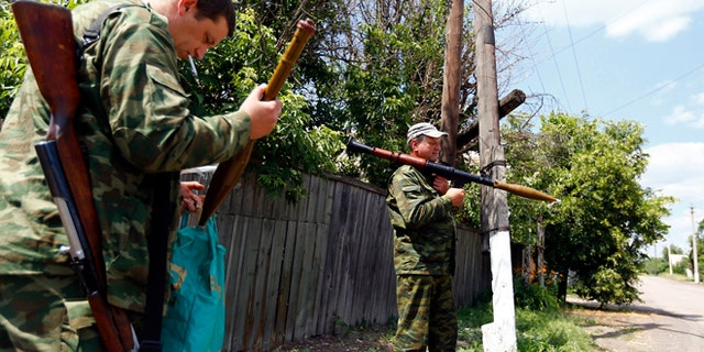 June 19, 2014: Armed pro-Russian separatists stand guard in Seversk, located near the town of Krasny Liman, Donetsk region. Ukrainian troops and pro-Russian separatists were locked in fierce fighting in the east of Ukraine on Thursday after rebels rejected a call to lay down their arms in line with a peace plan proposed by President Petro Poroshenko, government forces said.
