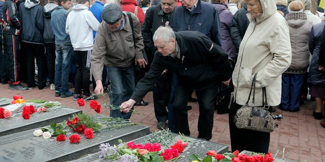 April 26, 2016: Ukrainians lay flowers to the tombstone that bears their relative's names, during a ceremony to commemorate victims of Chernobyl tragedy at a monument to them in Ukraine's capital Kiev, Ukraine.
