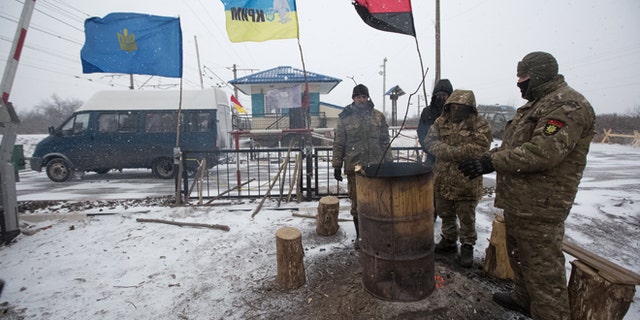 Activists warm themselves at a fire in a camp at Kryvyi Torets station as they take part in a rail blockade that has halted coal supplies in the village of Shcherbivka in Donetsk region, Ukraine, February 14, 2017.