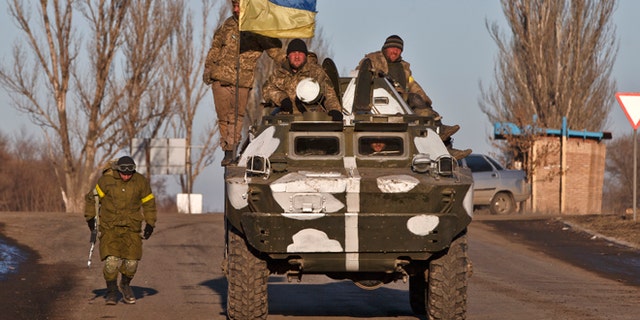 Ukrainian troops ride on an armored vehicle outside Artemivsk, Ukraine, while pulling out of Debaltseve.