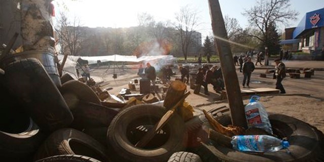 April 16, 2014: People gather in front of a barricade across a street in Slovyansk, eastern Ukraine. The city of Slovyansk has come under the increasing control of the pro-Russian gunmen who seized it last weekend.
