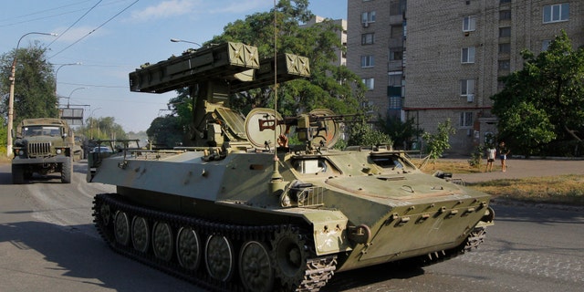 FILE - In this is Sunday, Aug. 17, 2014 file photo, a pro-Russian missile launcher drives in the town of Krasnodon. (AP Photo/Sergei Grits, File)