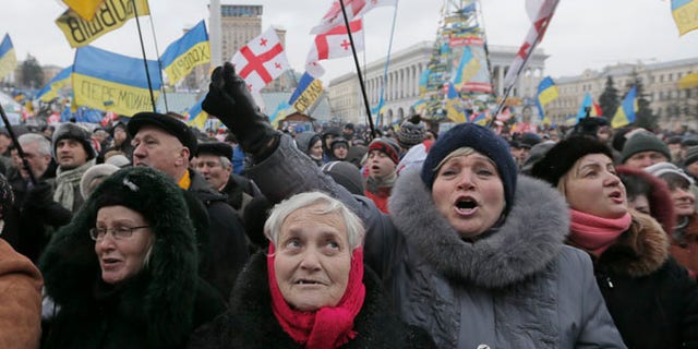Pro-European Union activists shout slogans during a rally in the Independence Square in Kiev, Ukraine, Saturday, Dec. 7, 2013. As thousands of anti-government protesters kept their vigil in Ukraine's capital Saturday, officials sought to reduce their anger with assurances that Russian and Ukrainian presidents didnt discuss Ukraine joining a Russian-led customs union at a meeting this week. (AP Photo/Efrem Lukatsky)