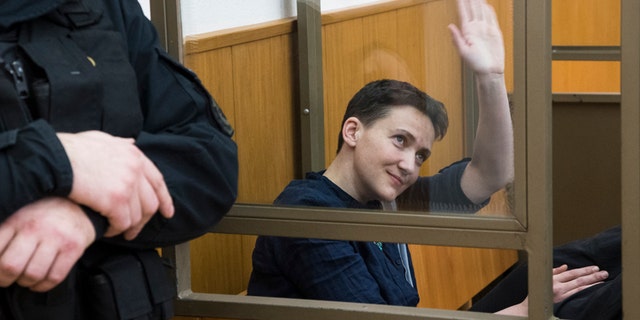 March 22, 2016: Ukrainian pilot Nadezhda Savchenko waves to journalists from a glass cage inside court, in the town of Donetsk, Rostov-on-Don region, Russia.