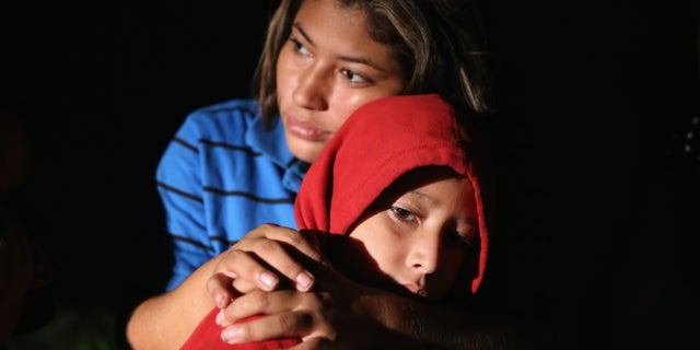 MISSION, TX - SEPTEMBER 08:  Families of Central American immigrants, including Lorena Arriaga, 27, and her son Jason Ramirez, 7, from El Salvador, turn themselves in to U.S. Border Patrol agents after crossing the Rio Grande River from Mexico on September 8, 2014 to Mission, Texas. Although the numbers of such immigrant families and unaccompanied minors have decreased from a springtime high, thousands continue to cross in the border illegally into the United States. Texas' Rio Grande Valley sector is the busiest area for illegal border crossings, especially for Central Americans, into the U.S.  (Photo by John Moore/Getty Images)