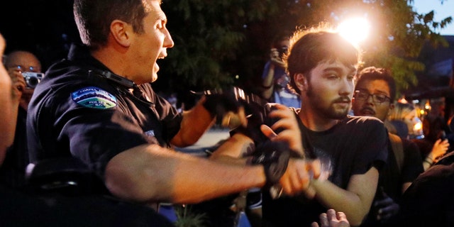 Police struggle with a protester during unrest at a demonstration against a statue of a Confederate soldier nicknamed Silent Sam on the campus of the University of North Carolina in Chapel Hill, North Carolina, U.S. August 22, 2017. REUTERS/Jonathan Drake - RC1596B5E160
