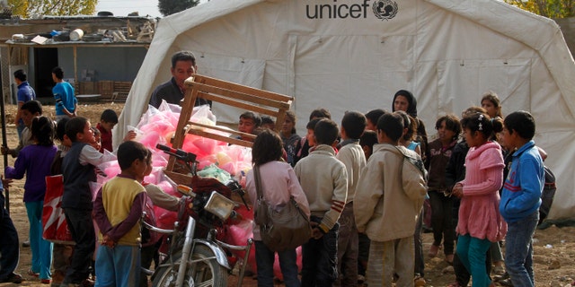Syrian refugee children gather around a UNICEF tent at a Syrian refugee camp near Zahle town in the Bekaa Valley November 8, 2013. (REUTERS/Sharif Karim)