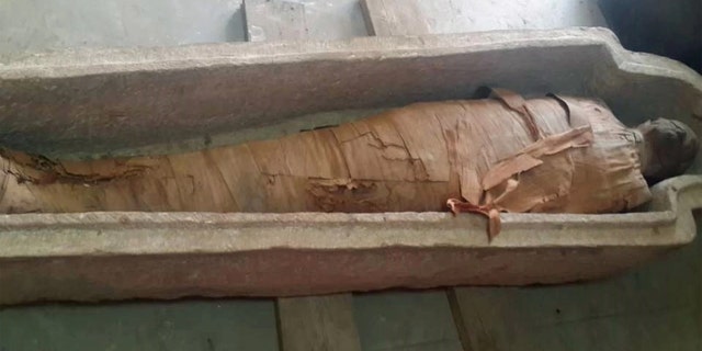 This well-preserved mummy, wrapped in linen bandages, was found inside a sandstone sarcophagus in a 2,500-year-old tomb at Aswan, in southern Egypt. The identity of the mummy is unclear. Credit: Photo courtesy of the Egyptian Ministry of Antiquities