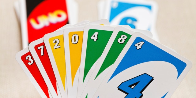 MOSCOW, RUSSIA - FEBRUARY 3, 2014: Uno card game in player hand. The game was developed by Merle Robbins in USA in 1971, and it has been Mattel product since 1992