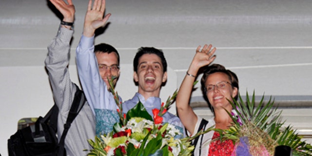 Sept. 24: Freed Americans Shane Bauer, left, Josh Fattal, center, and Sarah Shourd, right, Bauer's fiance, wave from the door to an airplane before leaving for the United States at the airport in Muscat, Oman.