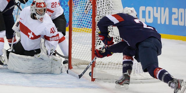 Feb. 10, 2014: Goalkeeper Florence Schelling of Switzerland watches as Amanda Kessel of the Untied States shoot slides in for the goal during the first period of the 2014 Winter Olympics women's ice hockey game at Shayba Arena in Sochi, Russia.