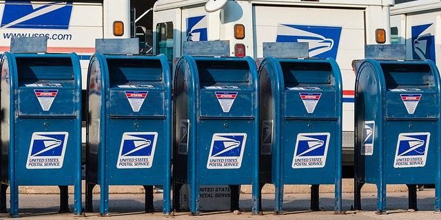 FILE - Five USPS drop boxes outside a post office.