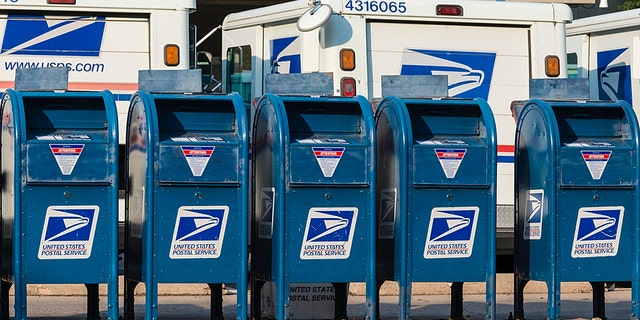 FILE - Five USPS drop boxes outside a post office.