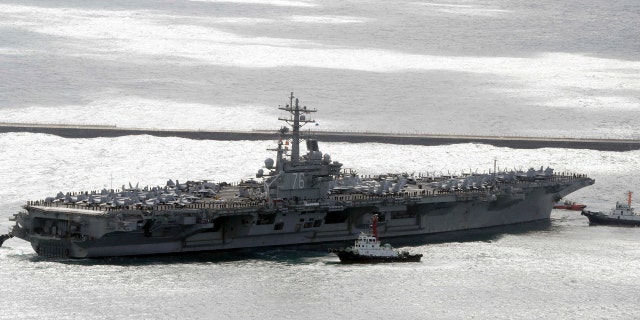 The aircraft carrier USS Ronald Reagan is escorted into Busan port, South Korea, after completing a joint drill.