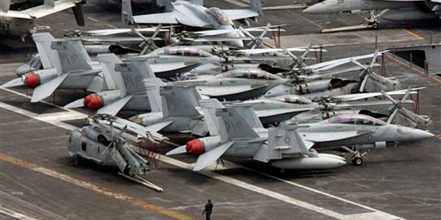 July 24, 2010: An armed military personnel stands near a flight line on the deck of U.S. nuclear-powered aircraft carrier USS George Washington at the Busan port in Busan, south of Seoul, South Korea.