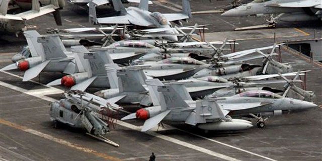 July 24, 2010: An armed military personnel stands near a flight line on the deck of U.S. nuclear-powered aircraft carrier USS George Washington at the Busan port in Busan, south of Seoul, South Korea.