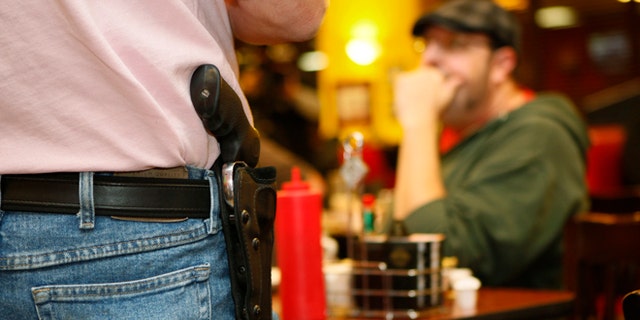 FILE: Nov. 1, 2012: A Oklahoma resident wears an unconcealed side arm at Beverly's Pancake House in Oklahoma City, Okla., a state that passed a concealed-carry law last year.