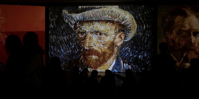 File photo - Visitors look at a projection of Vincent Van Gogh's painting "Self-Portrait with Grey Felt Hat" at the "Van Gogh Alive" exhibition in Athens, Greece, November 10, 2017. Picture taken Nov. 10, 2017. (REUTERS/Alkis Konstantinidis)
