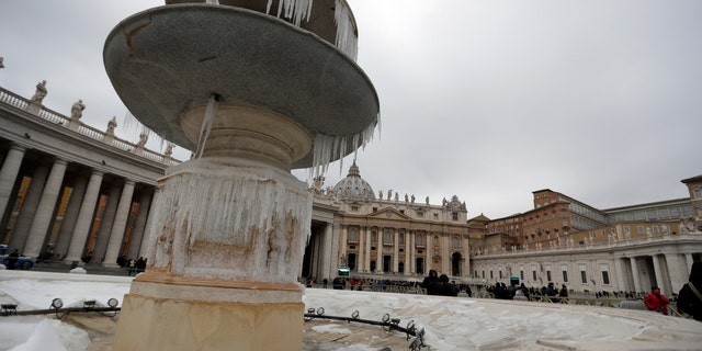 Des glaçons de neige ornent l'une des fontaines de la place Saint-Pierre au Vatican.