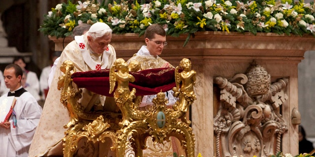 Dec. 24, 2011: Pope Benedict XVI kneels in prayer as he celebrates Christmas Mass in St. Peter's Basilica at the Vatican.