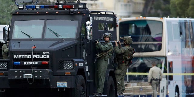 Las Vegas SWAT officers leave the scene of a stand-off in a bus along Las Vegas Boulevard, Saturday, March 25, 2017, in Las Vegas. Las Vegas police said the gunman in a fatal shooting on the Strip who barricaded himself inside a public bus has surrendered peacefully after shutting down the busy tourism corridor for hours. (AP Photo/John Locher)
