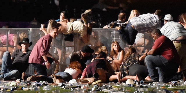 People scramble for shelter at the Route 91 Harvest country music festival after gun fire was heard on October 1, 2017 in Las Vegas, Nevada.