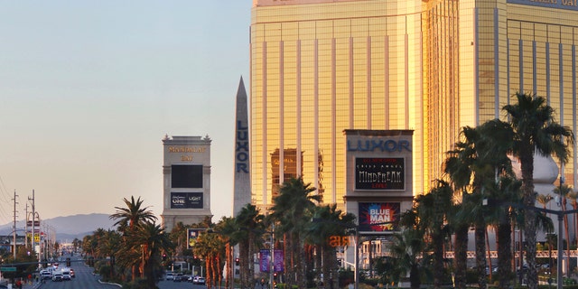 Police block a road on the Las Vegas Strip near the Mandalay Bay hotel and casino shortly after sunrise Monday, Oct. 2, 2017, in Las Vegas. A deadly shooting occurred late Sunday at a music festival on the Las Vegas Strip. (AP Photo/Ronda Churchill)