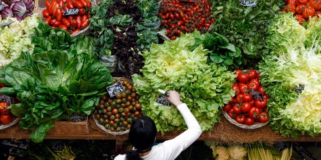 An employee arranges pricetags at a vegetables work bench during the opening day of upmarket Italian food hall chain Eataly's flagship store in downtown Milan, March 18, 2014. REUTERS/Alessandro Garofalo