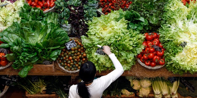 An employee arranges pricetags at a vegetables work bench during the opening day of upmarket Italian food hall chain Eataly's flagship store in downtown Milan, March 18, 2014. REUTERS/Alessandro Garofalo