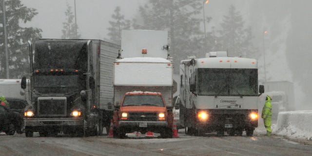 Vehicles pass through a California Departement of Transportation chain inspection stop on eastbound Interstate 80 near Alta, Calif., Thursday March 24, 2011. (AP)