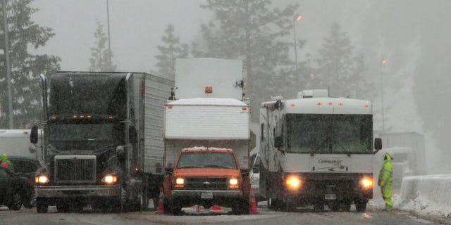 Vehicles pass through a California Departement of Transportation chain inspection stop on eastbound Interstate 80 near Alta, Calif., Thursday March 24, 2011. (AP)
