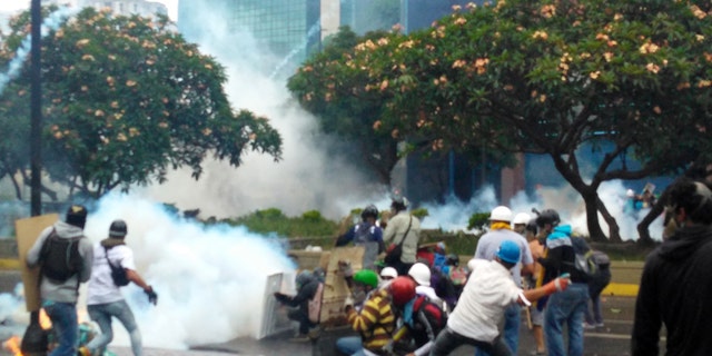 Demonstrators throw rocks and Molotov cocktails against police in a riot against Nicolas Maduro.