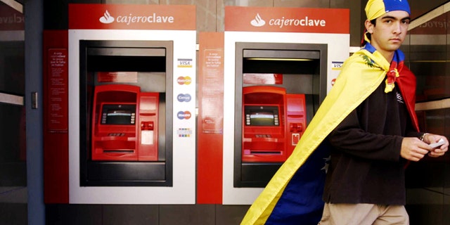 CARACAS, VENEZUELA - A Venezuelan resident walks away from an ATM at a bank on January 9, 2003 in Caracas, Venezuela. An official with the Venezuelan Bank Association said the strike forced 70 percent of bank branches nationwide to close due to the nation wide two-day bank strike. (Photo by Susana Gonzalez/Getty Images)