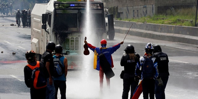 A demonstrator stands in front of a riot security forces vehicle during a rally against President Nicolas Maduro in Caracas, Venezuela, May 24, 2017.