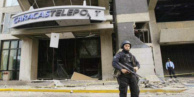 CARACAS, VENEZUELA - APRIL 12:  A police man guards a building where a bomb exploded April 12, 2003 in Caracas, Venezuela. A bomb ripped through a building where government and opposition negotiators had agreed to hold a referendum on President Hugo Chavez. This blast follows several other bomb explosions in the last six weeks and falls on the year anniversary of a brief coup attempt against President Chavez. (Photo by Kimberly White/Getty Images)