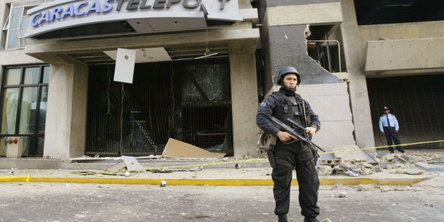 CARACAS, VENEZUELA - APRIL 12: A police man guards a building where a bomb exploded April 12, 2003 in Caracas, Venezuela. A bomb ripped through a building where government and opposition negotiators had agreed to hold a referendum on President Hugo Chavez. This blast follows several other bomb explosions in the last six weeks and falls on the year anniversary of a brief coup attempt against President Chavez. (Photo by Kimberly White/Getty Images)