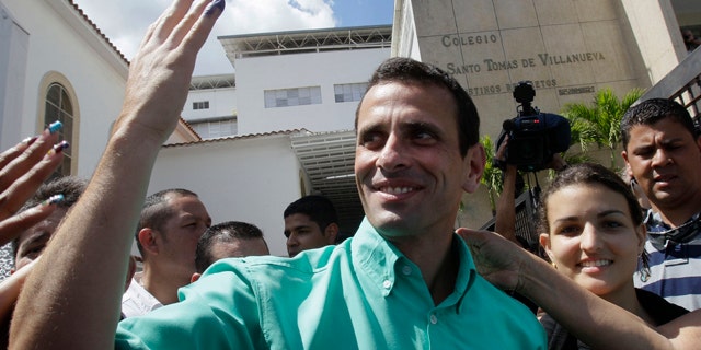 Feb. 12, 2012: Henrique Capriles, the front-runner among five opposition presidential contenders, shows off his ink-stained pinky as he leaves a polling station in Caracas, Venezuela.