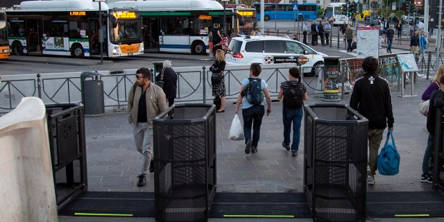 In this photo taken on Friday, April 27, 2018, people walk through gates in Venice, Italy.
