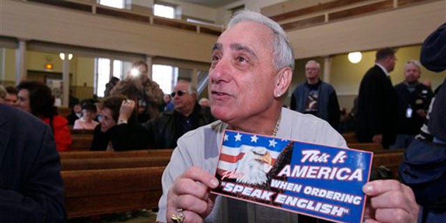 In this Dec. 14, 2007 file photo, Joey Vento, owner of Geno's Steaks, displays a sign during a recess of a Commission on Human Relations hearing in Philadelphia.