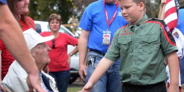 Nov. 7, 2015: Jackson Cannon, 10, of Trail Life USA-Troop 33, shakes hands with World War II veteran Ernest Noble, 95, during a Veteran's Day ceremony at Pearson Park in Kinston, N.C. Noble fought in Belgium, Luxemburg, Holland and Germany. In March of 1945 he helped liberate concentration camps. (Zach Frailey/Daily Free Press via AP)