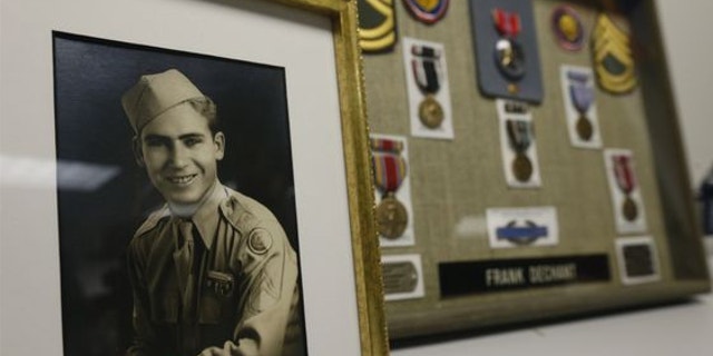 April 14, 2014: A framed photo and medals, including a Bronze Star, sit on display during a ceremony at which 91-year-old World War II veteran Frank Dechant received the United States Prisoner of War Medal, in Lakewood, Colo.